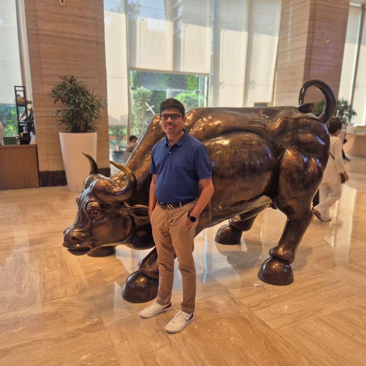 Dhaval Parikh standing by the Wall Street Charging Bull